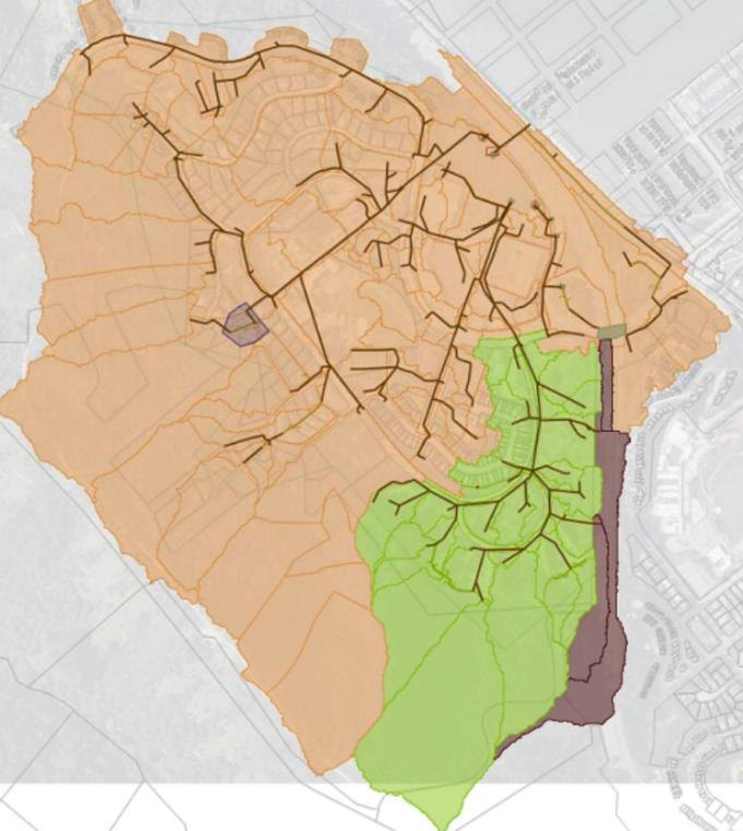 A watershed map of Marin City. A large tan area covers most of the bowl. A green area in the southeast is labeled the Drake system watershed. A narrow brown strip runs down the eastern edge alongside the highway alignment, marking the Caltrans drainage area that flows into Marin City.